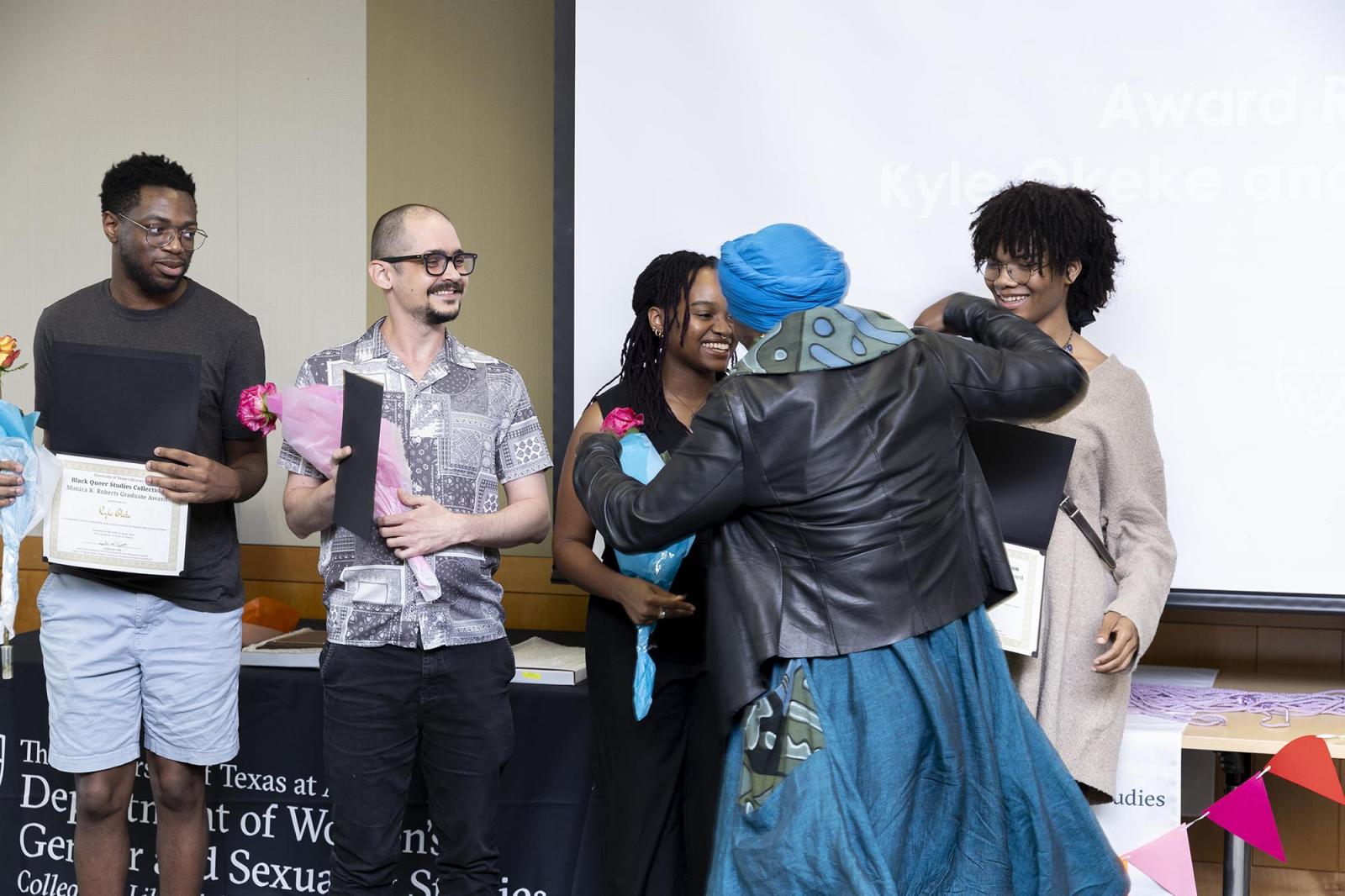 Students receiving congratulations from a faculty member.