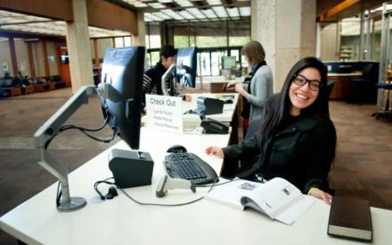 a smiling librarian behind an information desk